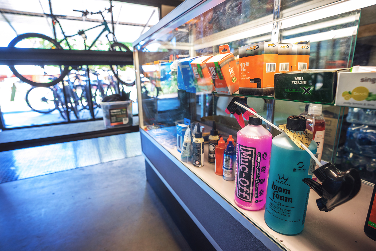 Hydration bottles, tyre sealant and bike care products on shop shelf