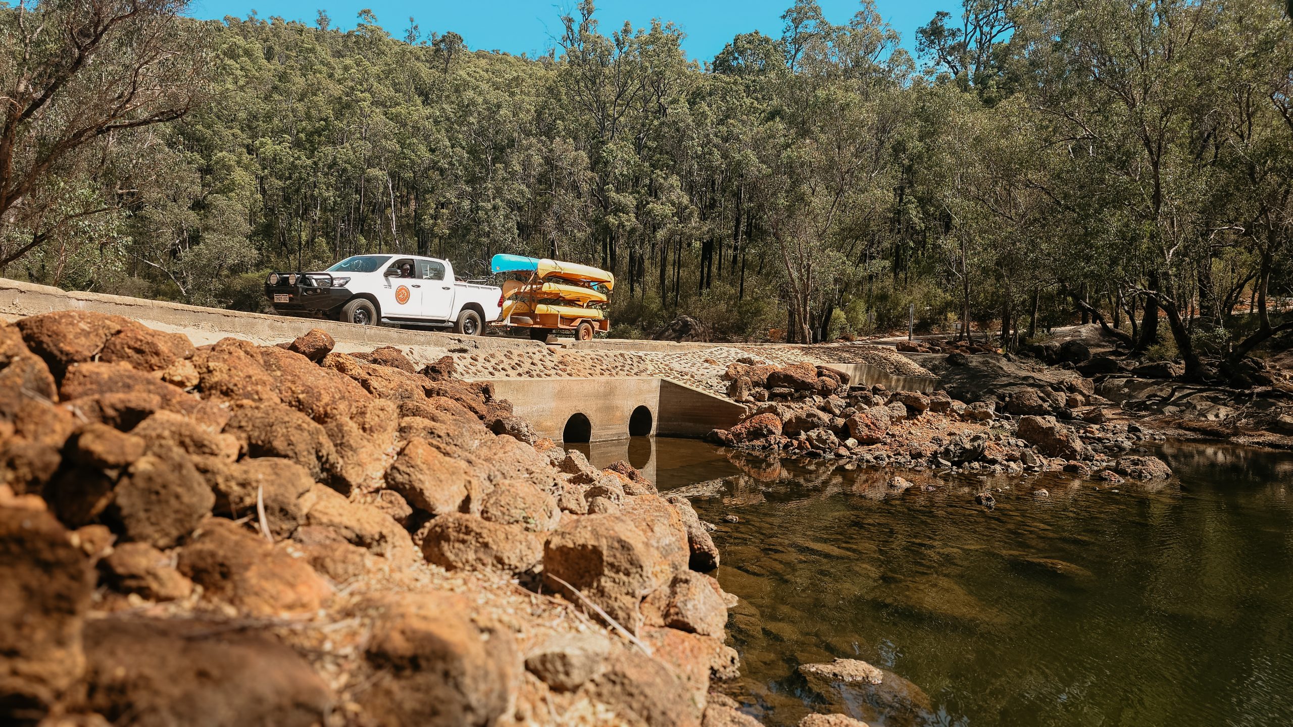 Charter 4WD with rafts crossing river causeway in Dwellingup