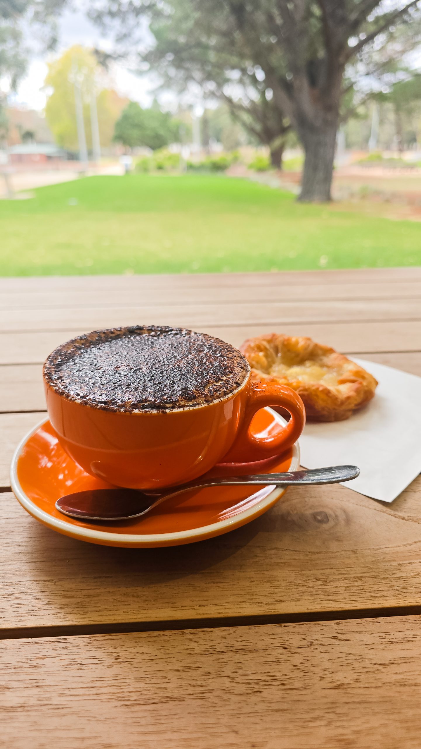 Flat white coffee and pastry outdoors – coffee break at Dwellingup cafe